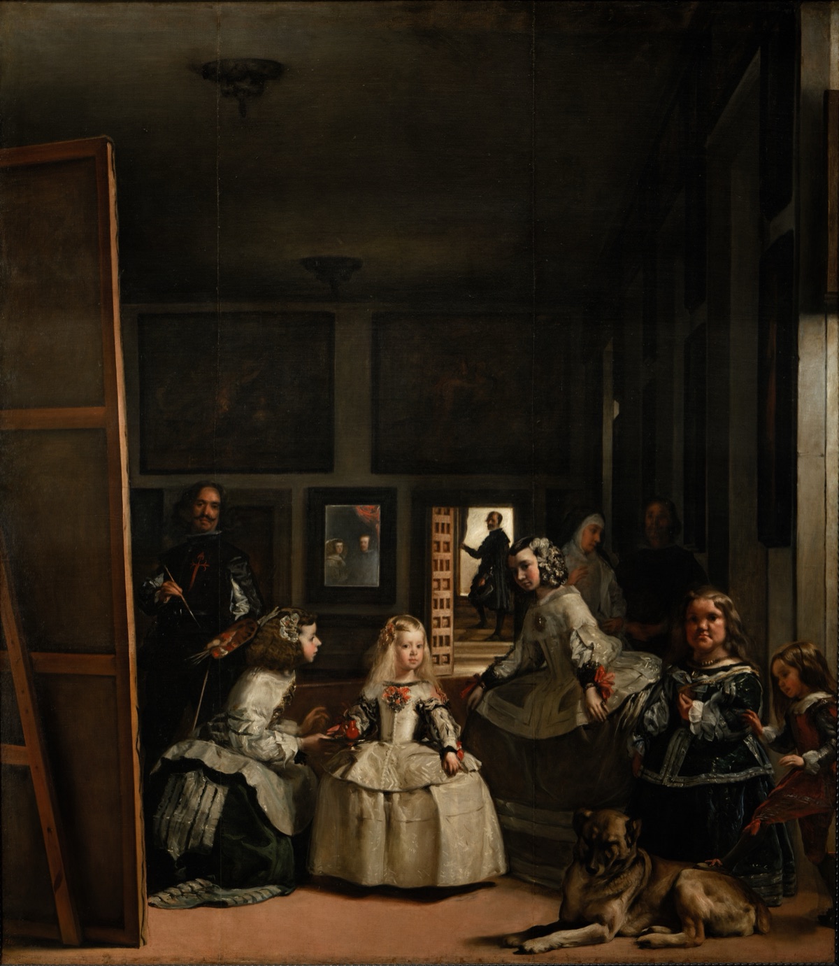 Las Meninas, de Diego Velázquez: una petita princesa rossa amb un ampli vestit blanc és dreta en una sala de palau alta i en penombra entre dues dames que s’inclinen, amb el pintor davant d’un llenç enorme a l’esquerra, una nana i un gran gos ajagut en primer pla a la dreta, un mirall a la paret del fons i un home en una porta il·luminada.